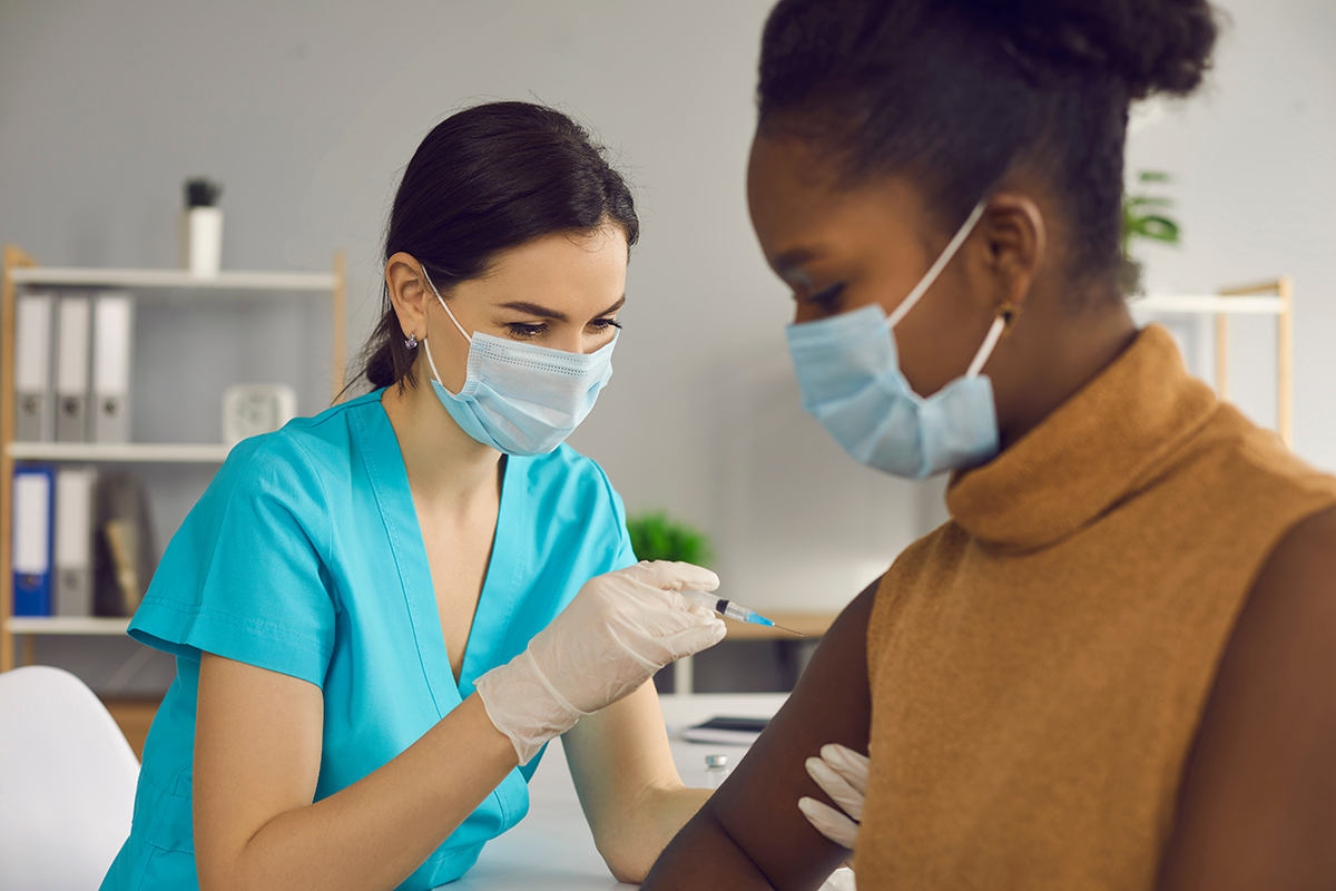 A health care worker administers a vaccination to a young patient